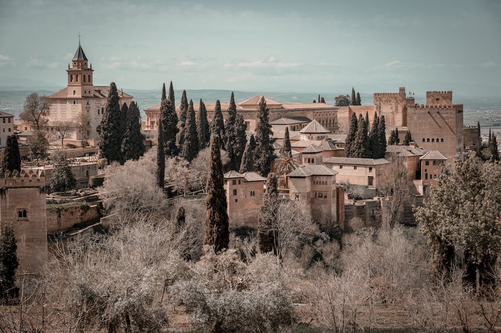 Scenic view of the historic Alhambra Palace surrounded by lush trees in Granada, Spain.
